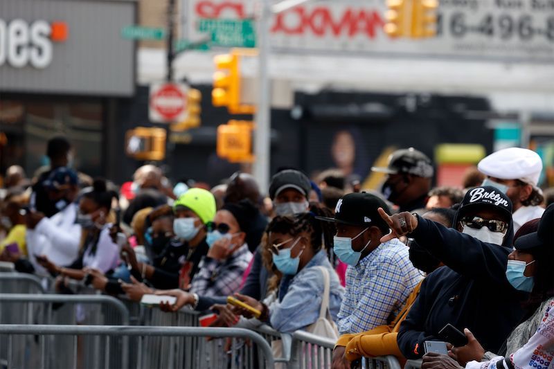 A crowd of masked people stand by metal barricades outside the Barclays Center in Brooklyn, waiting for iconic rapper DMX's memorial.